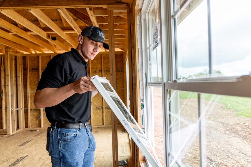 man checking on window installation during construction process